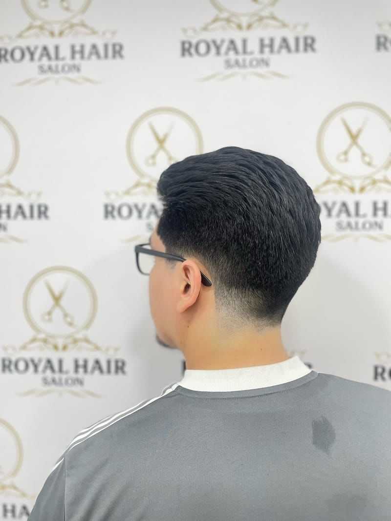 Man with a fresh haircut, facing away, at Royal Hair Salon.